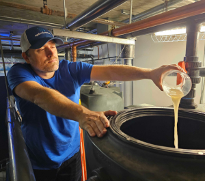 Epic O&M operator Ryan pouring chemicals into a reuse system