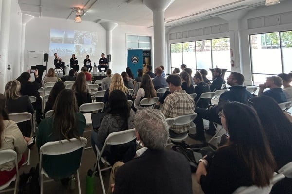 A view from the back of the room showing the audience and four speakers on stage during Epic + USGBC event in August